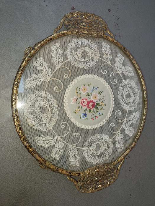 A VINTAGE ART DECOR SERVING TRAY WITH LACE WORK IN THE GLASS SOLD AS IS