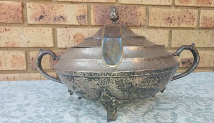 AN ANTIQUE SILVER PLATED TUREEN WITH A LADLE SOLD AS IS