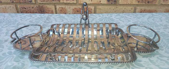 A VINTAGE ROAST TRAY WITH SAUCE HOLDERS AND A SCALLOPED HANDLE
