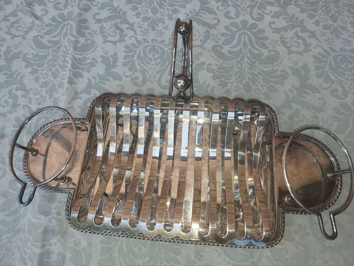 A VINTAGE ROAST TRAY WITH SAUCE HOLDERS AND A SCALLOPED HANDLE