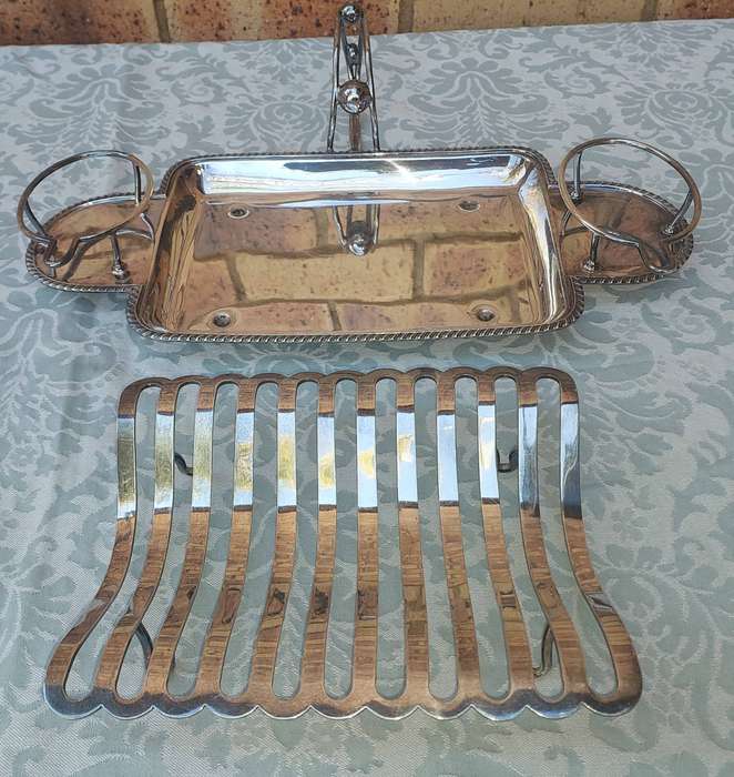 A VINTAGE ROAST TRAY WITH SAUCE HOLDERS AND A SCALLOPED HANDLE