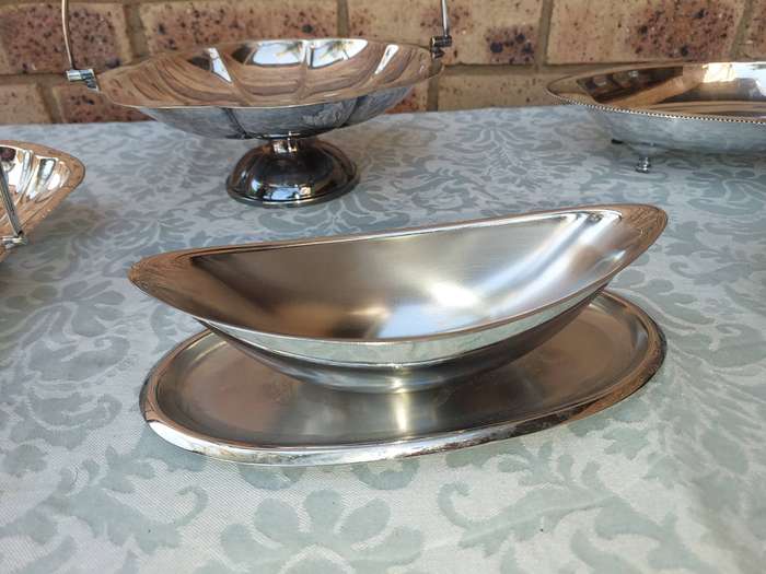 A COLLECTION OF SILVERPLATED AND STAINLESS STEEL WEDDING BASKET SERVING TRAYS