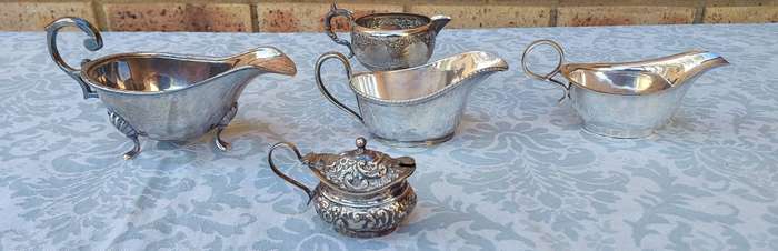 A VINTAGE COLLECTION OF SAUCE BOATS AND JUGS SOLD AS IS