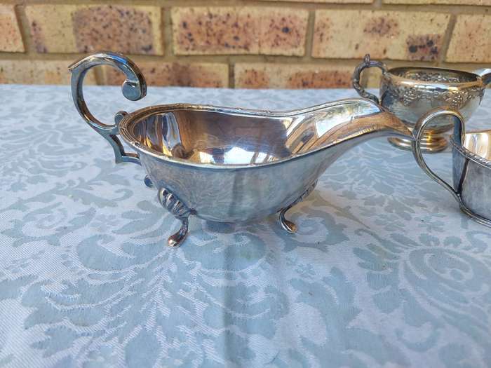 A VINTAGE COLLECTION OF SAUCE BOATS AND JUGS SOLD AS IS