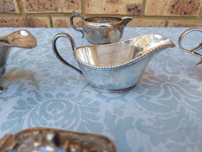 A VINTAGE COLLECTION OF SAUCE BOATS AND JUGS SOLD AS IS