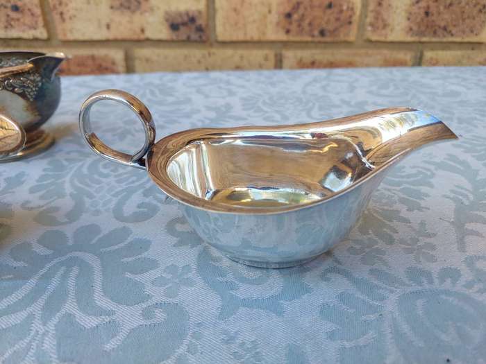 A VINTAGE COLLECTION OF SAUCE BOATS AND JUGS SOLD AS IS