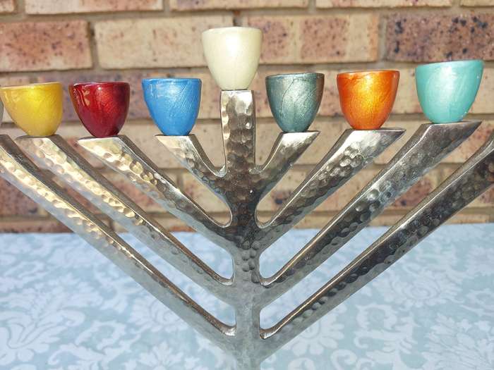 A BEAUTIFULL CHROME PLATED MINORA WITH LAQUERED CANDLE HOLDERS SOLD AS IS