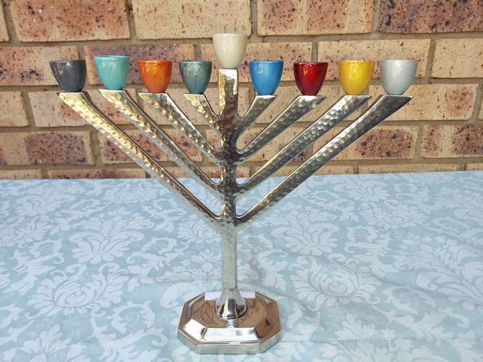A BEAUTIFULL CHROME PLATED MINORA WITH LAQUERED CANDLE HOLDERS SOLD AS IS
