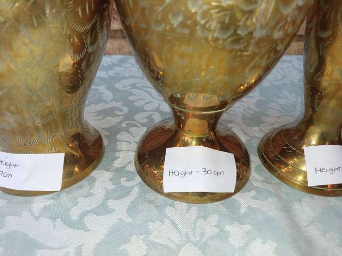 A COLLECTION OF BRASS VASES AND AN URN SOLD AS IS