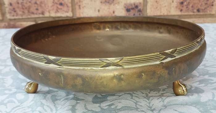 AN ORNATE VINTAGE BRASS SERVING BOWL WITH BALL AND CLAW LEGS SOLD AS IS