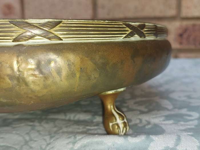 AN ORNATE VINTAGE BRASS SERVING BOWL WITH BALL AND CLAW LEGS SOLD AS IS