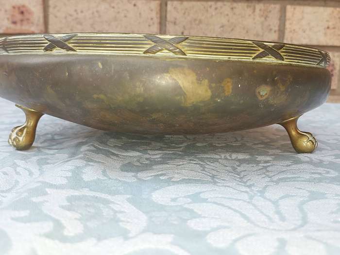 AN ORNATE VINTAGE BRASS SERVING BOWL WITH BALL AND CLAW LEGS SOLD AS IS