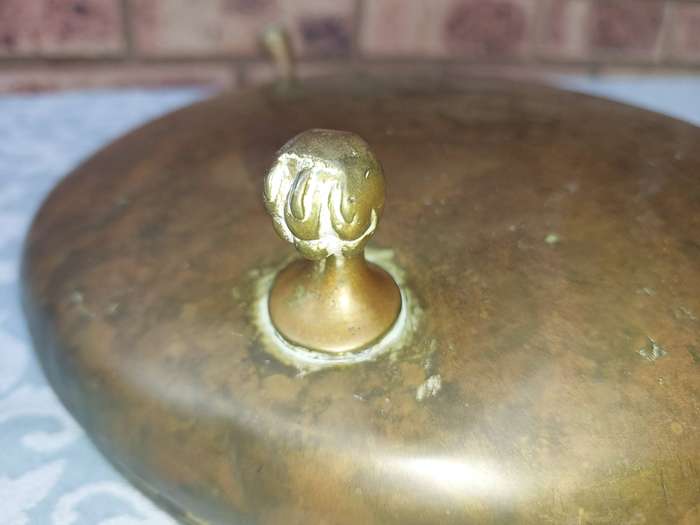AN ORNATE VINTAGE BRASS SERVING BOWL WITH BALL AND CLAW LEGS SOLD AS IS