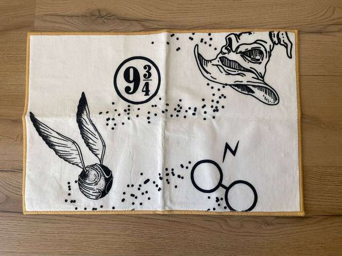 Harry Potter doormat featuring the Golden Snitch, Sorting Hat, and iconic house symbols