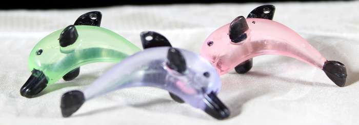 Miniature hardened plastic dolphin trio