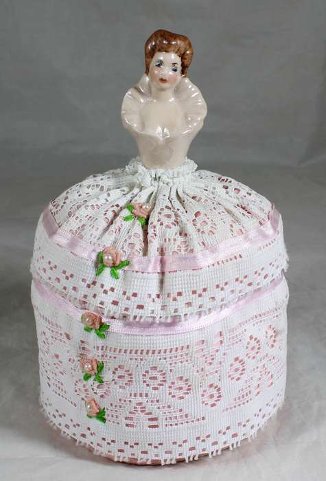 Half doll on a tall pin cushion