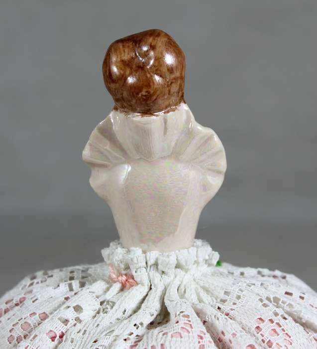 Half doll on a tall pin cushion