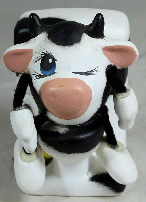Ceramic cow sitting on the toilet