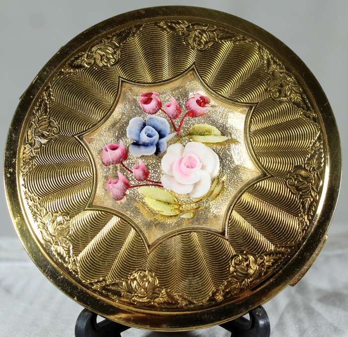 Encased flowers in golden powder compact