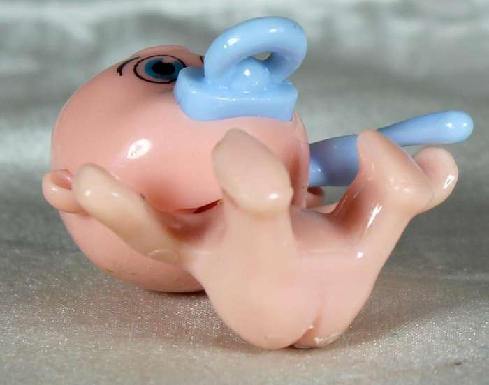 Miniature plastic baby with dummy and spoon