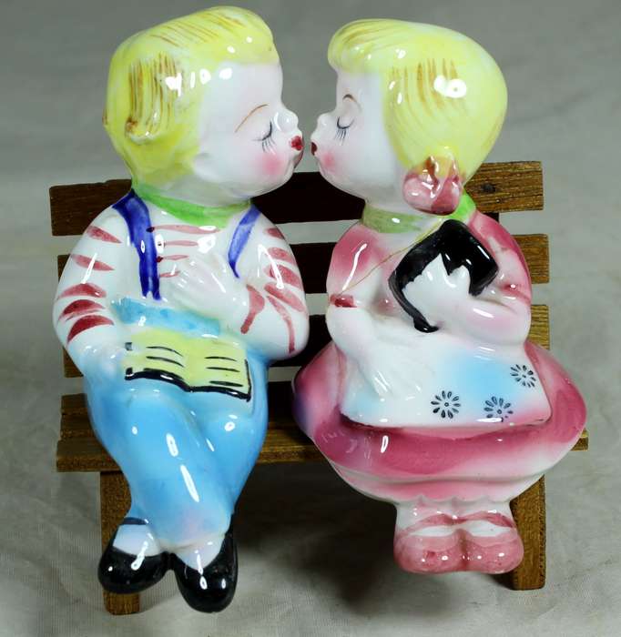 Kissing porcelain kids on a wooden bench