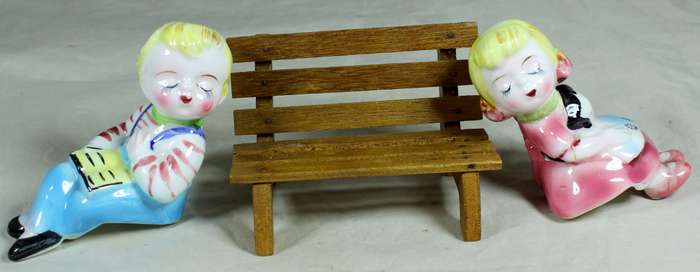 Kissing porcelain kids on a wooden bench