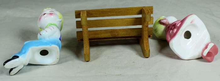 Kissing porcelain kids on a wooden bench