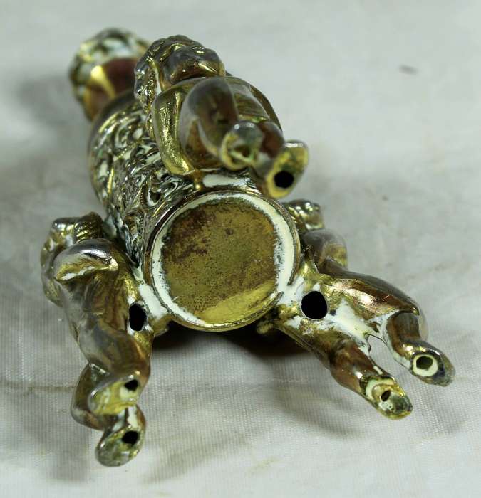 Small brass cherubs holding a perfume bottle