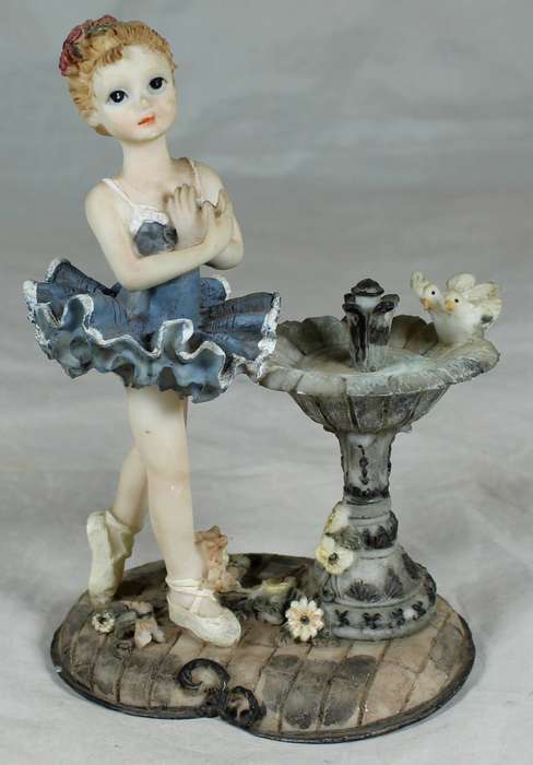 Resin ballerina next to a bird bath