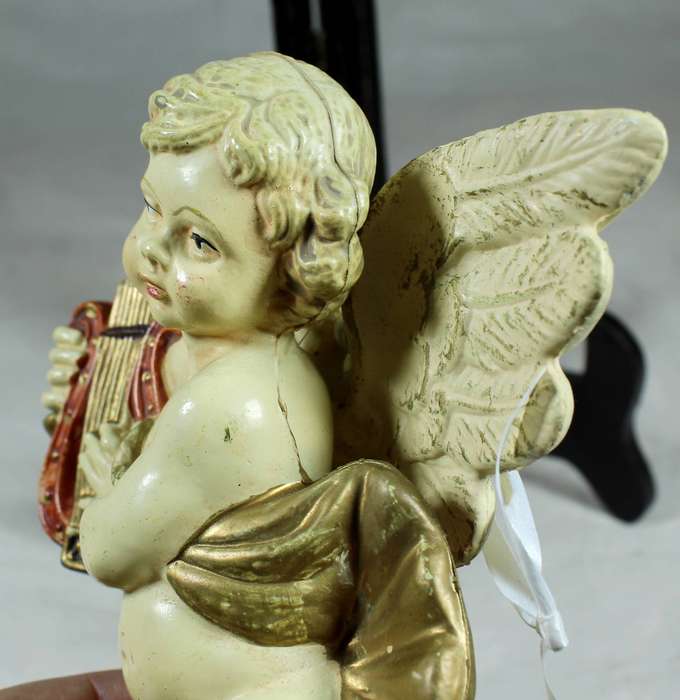 Plastic cherub playing a harp