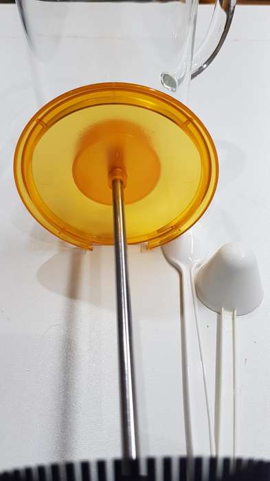 Glass coffee plunger with plastic lid and solid glass handle.