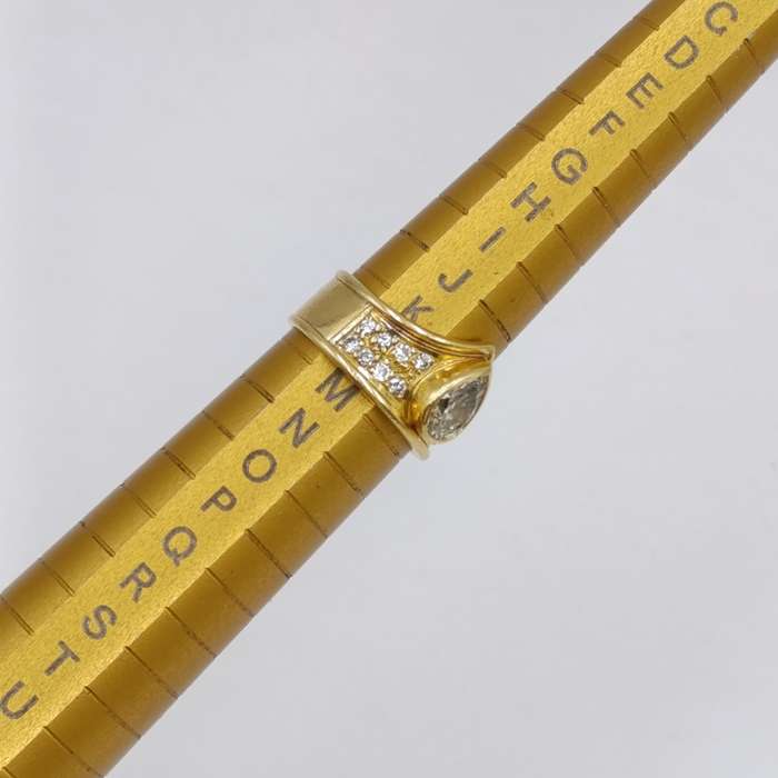 18Kt gold ring with 16 small diamonds and one large teardrop fancy yellow diamond of 0,87 carat