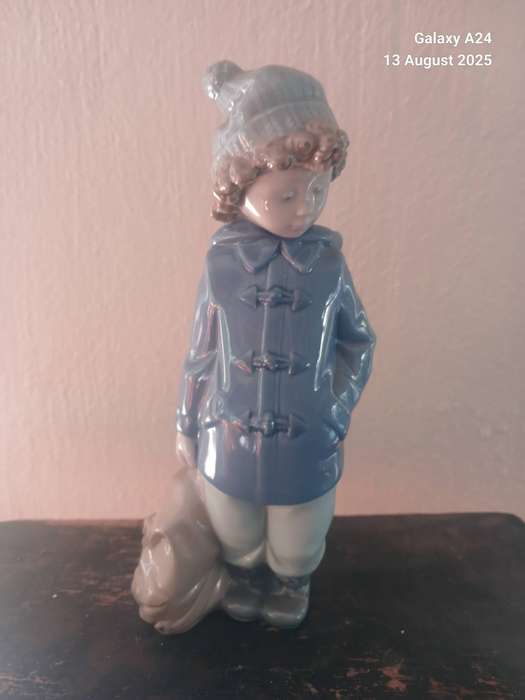 A Nao figurine of a boy holding a bag