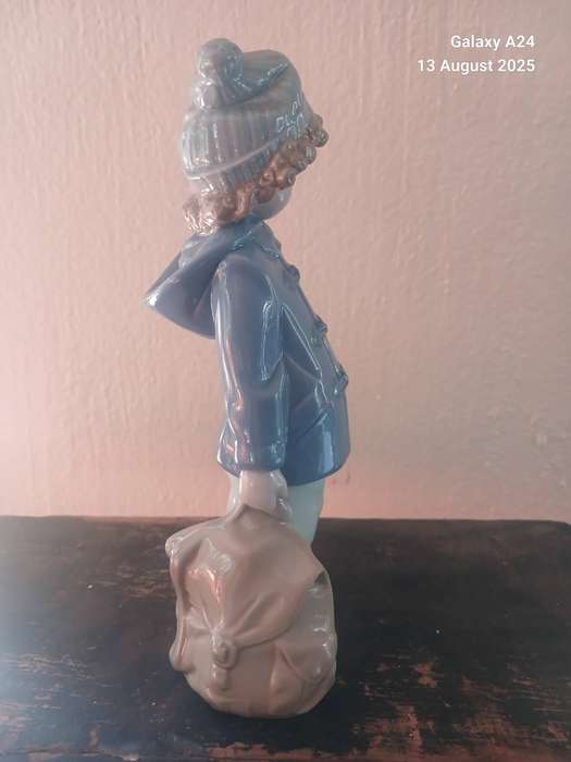 A Nao figurine of a boy holding a bag