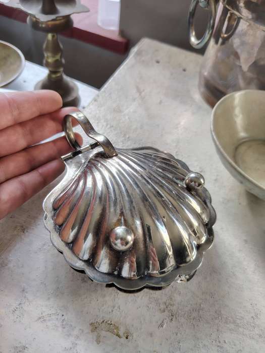 vintage silver-plated shell-shaped butter dish, often used for serving butter, caviar, or other cond