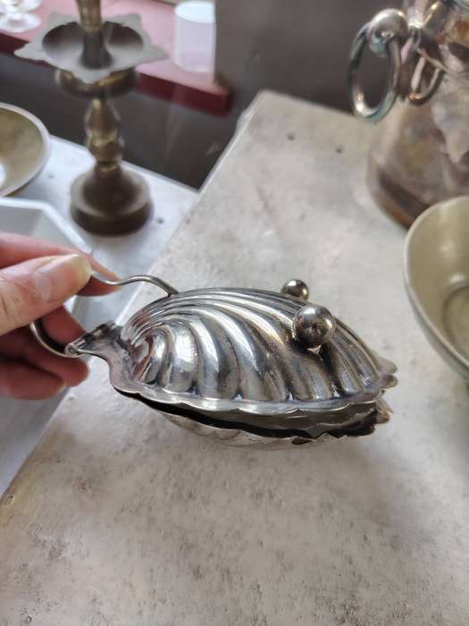 vintage silver-plated shell-shaped butter dish, often used for serving butter, caviar, or other cond