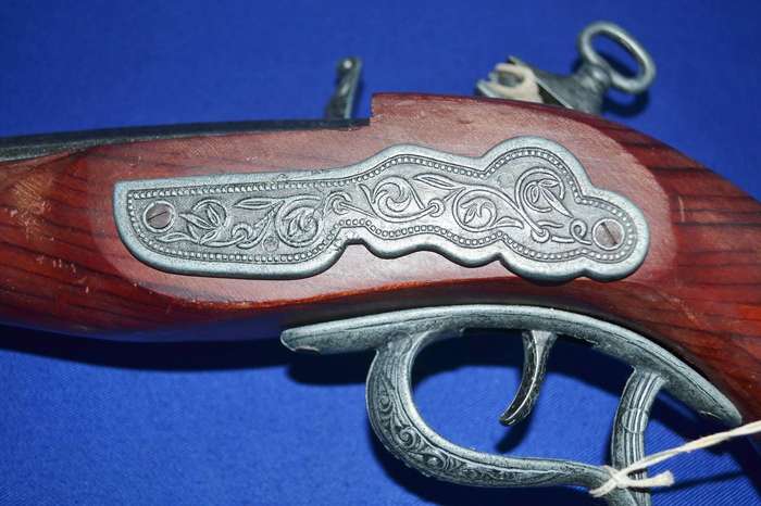 Vintage replica antique snaphance pistol displayed on wooden frame