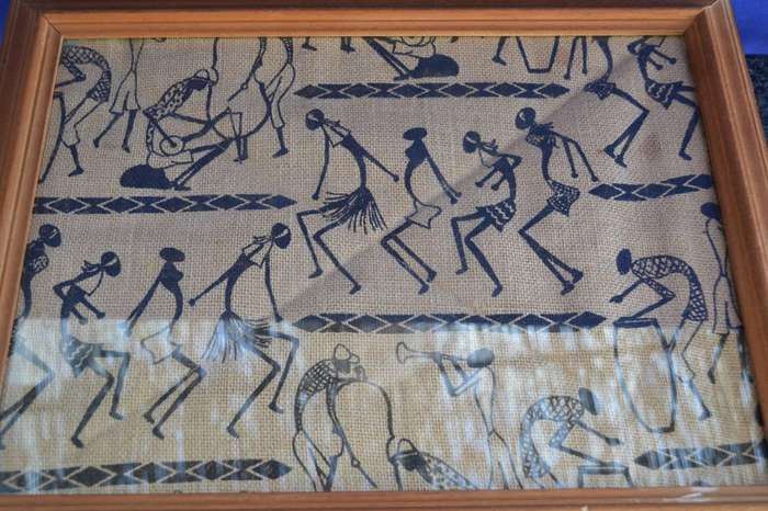 Black silhouette ethnic style stick figure art on quilted sacking