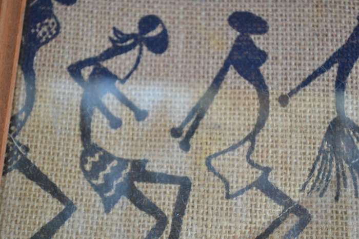 Black silhouette ethnic style stick figure art on quilted sacking