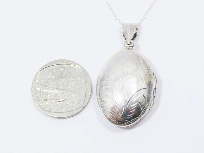 A Lovely Medium Size Oval Engraved Locket On Chain in Sterling Silver.