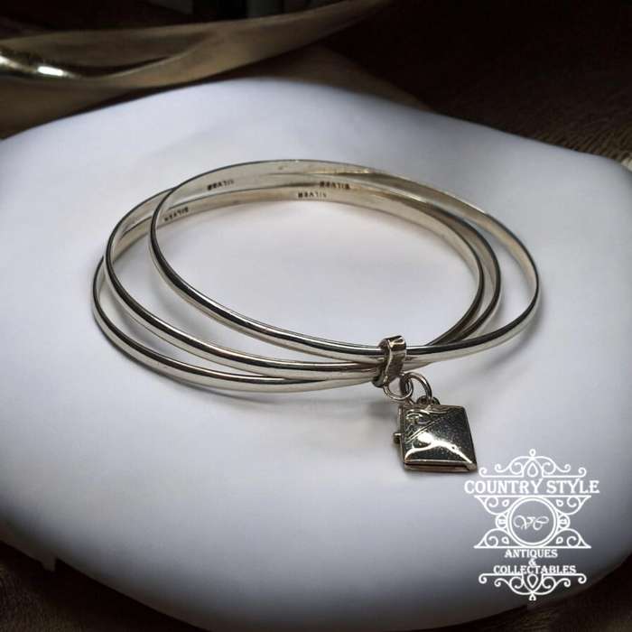 Trio of sterling silver bangles with a locket