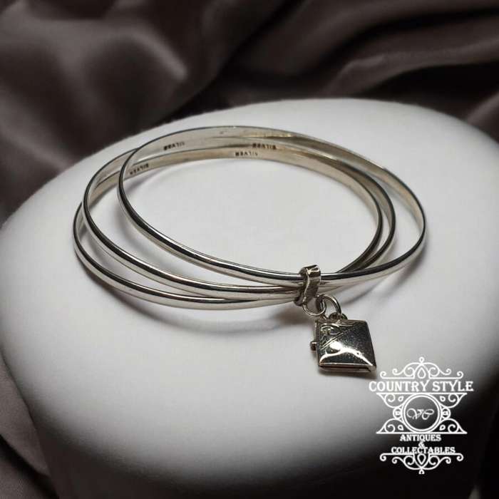 Trio of sterling silver bangles with a locket