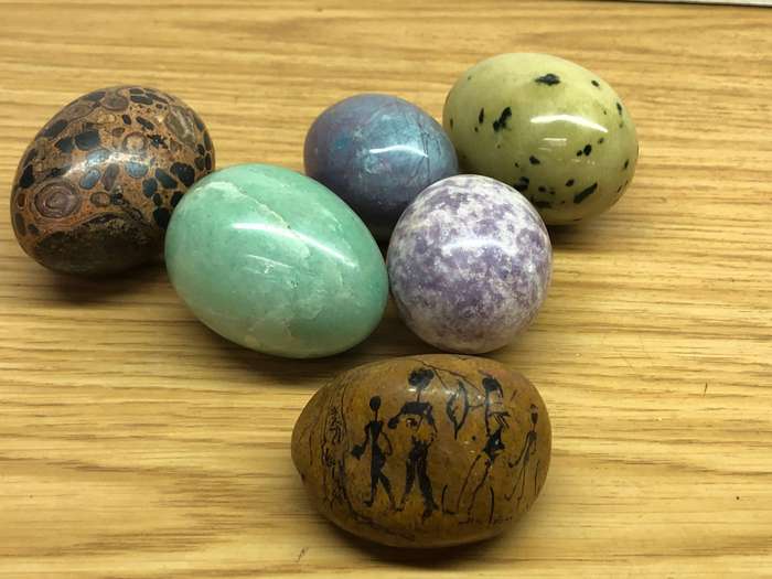 Collection of precious stone eggs and a bushmen painted rock