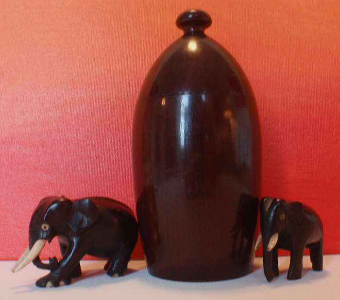 Beautifully carved wooden urn and two elephants .
