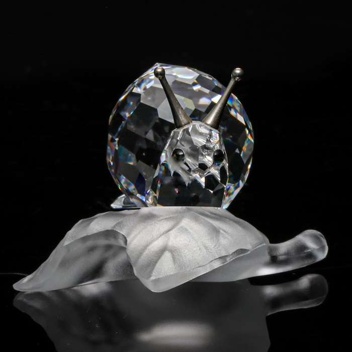 Swarovski Crystal Snail On A Vine Leaf Among Flowers and Foliage