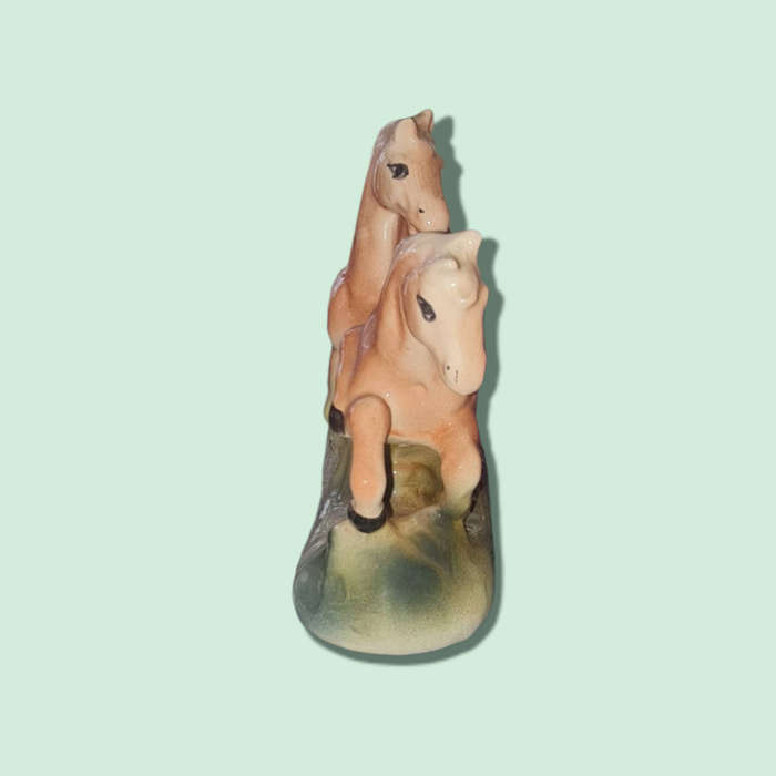A vintage china-made pair of stylized horses finished in a playful pink and green speckled glossy gl