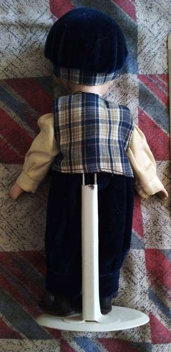 A BOY PORCELAIN DOLL IN GREAT CONDITION WITH STAND.