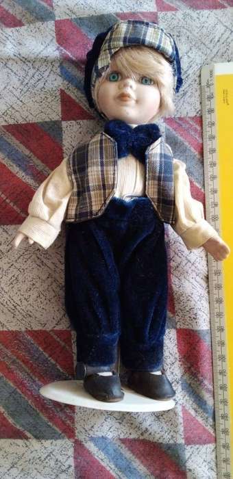 A BOY PORCELAIN DOLL IN GREAT CONDITION WITH STAND.