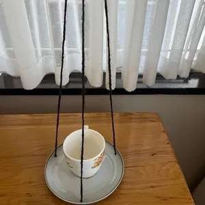 Used cup-and-saucer pottery bird feeder garden