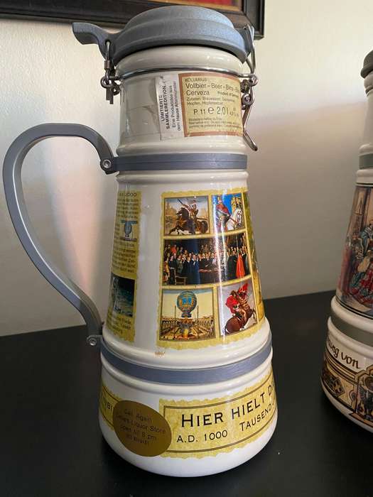 TWO VERY LARGE GERMAN,LIDDED BEER STEINS-PORCELEIN AND STILL SEALED (CONTENTS CANNOT BE GUARANTEED)L